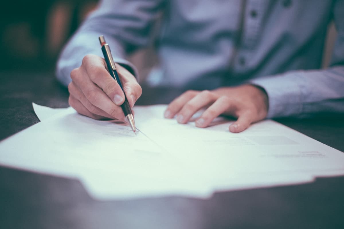 Hands reviewing and signing healthcare compliance documents